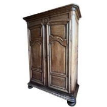 A LARGE 18TH CENTURY FRENCH OAK ARMOIRE Wth shaped panelled doors opening to reveal shelf interior