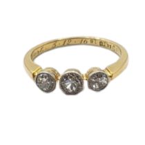 AN EARLY 20TH CENTURY 18CT GOLD AND DIAMOND THREE STONE RING Having a row of round cut diamonds in a