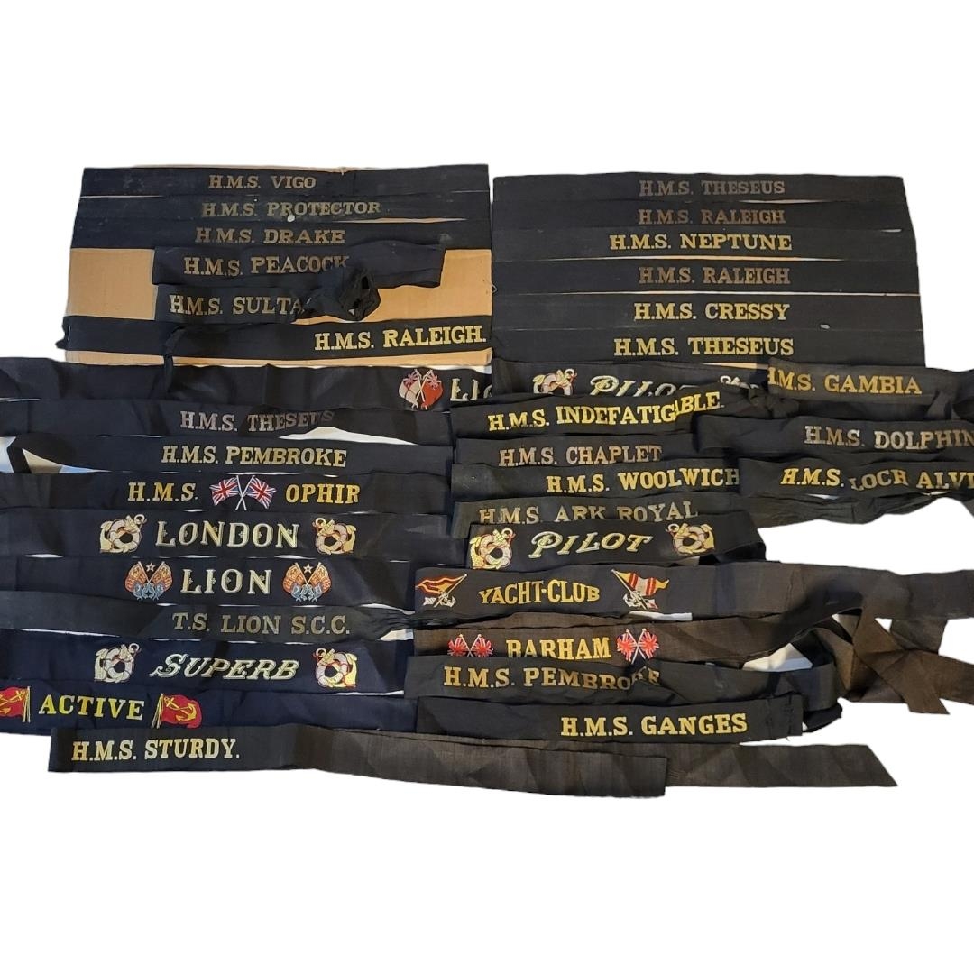 A COLLECTION OF THIRTY EARLY 20TH CENTURY BRITISH ROYAL NAVY CAP TALLY BANDS Gilt embroidery on