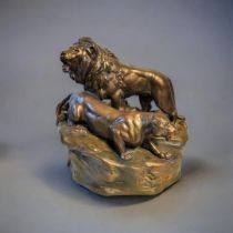 AN EARLY 20TH CENTURY POTTERY LION AND LIONESS Standing pose on textured base. (approx 40cm)