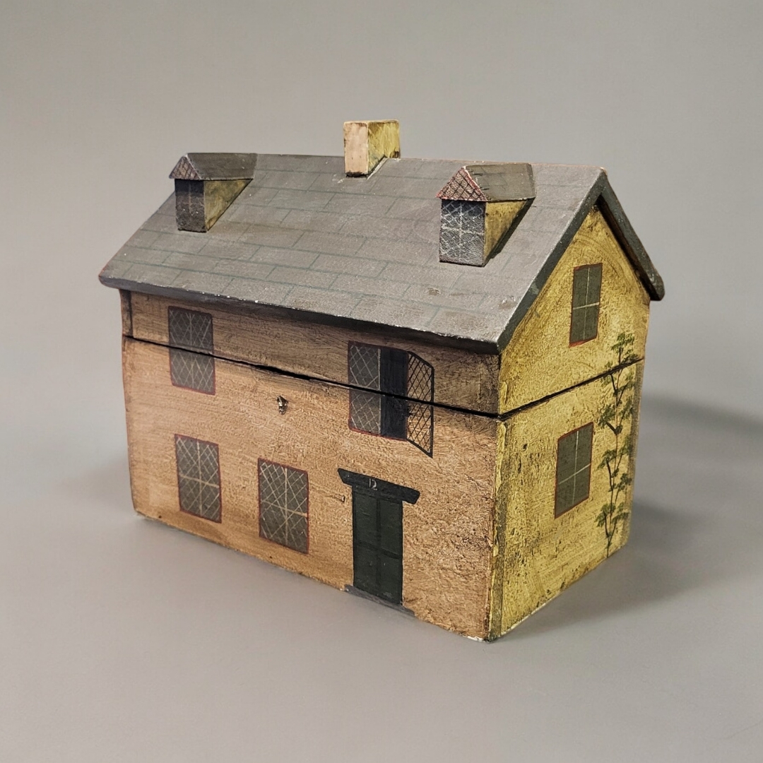 A WOODEN MODEL HOUSE TEA CADDY In the design of a 19th Century English cottage with painted floral