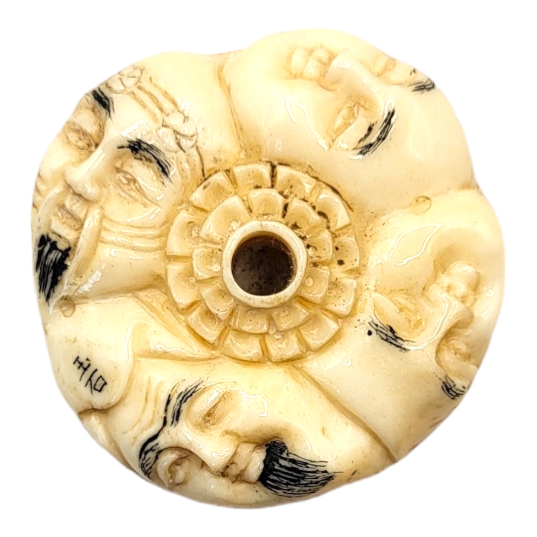 A JAPANESE BONE NETSUKE Circular form, with carved stylised faces to body. (4cm x 1.5cm) - Image 3 of 4