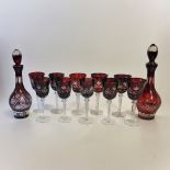 A BOHEMIAN FLASH CUT RUBY GLASS DRINKING SET To include two decanters and stoppers and ten large