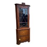 AN EARLY 19TH CENTURY MAHOGANY FLOOR-STANDING CORNER CABINET The single Gothic glazed door enclosing