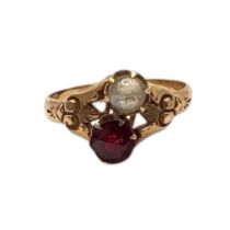 AN EARLY 20TH CENTURY YELLOW METAL GARNET AND MOONSTONE RING Having a round cut garnet and