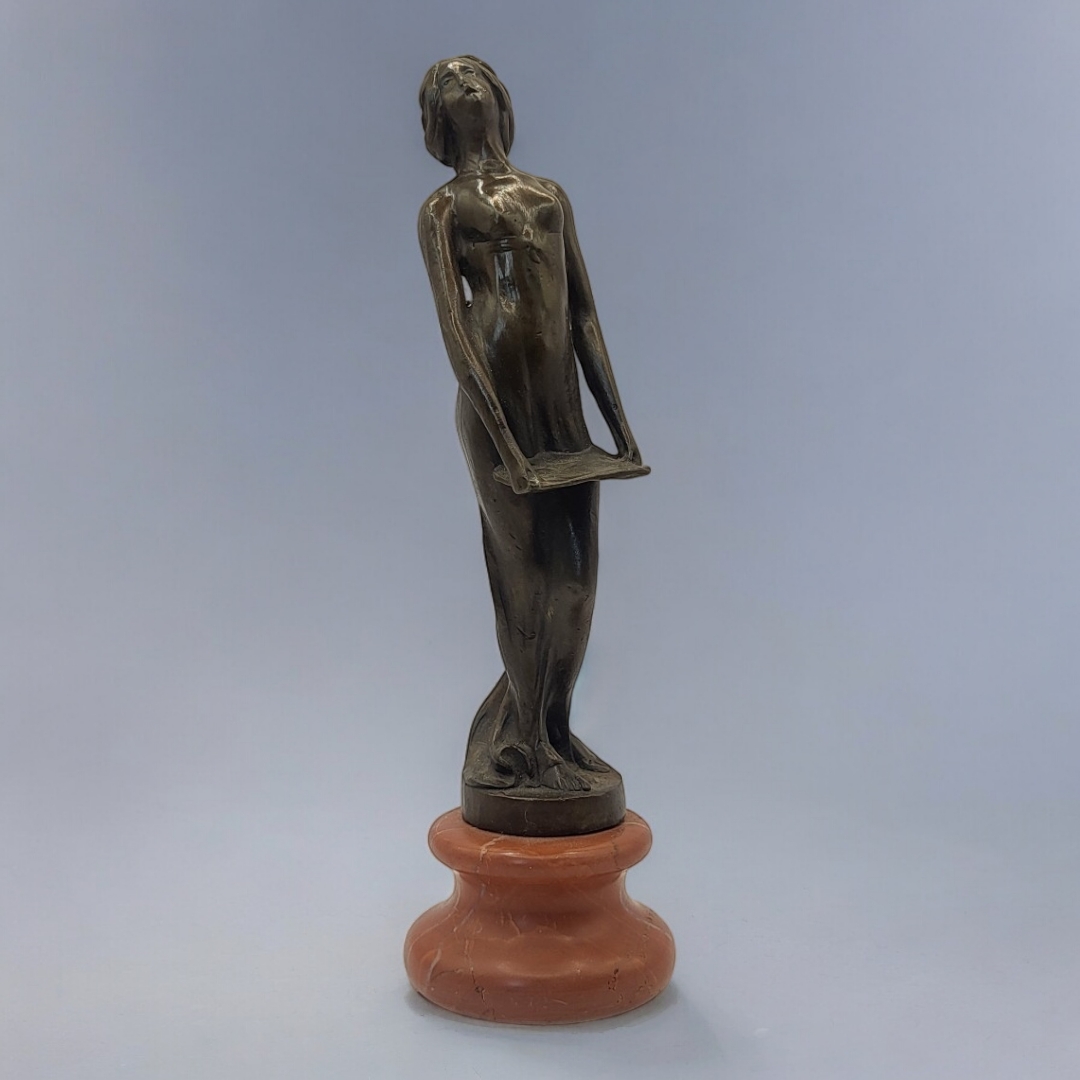 AN ART DECO STYLE BRONZE FIGURE FORMED AS A NUDE LADY HOLDING A MUSIC SHEET On rouge marble