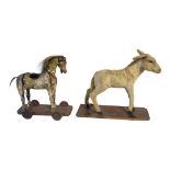 AN EARLY VICTORIAN CHILD'S TOY HORSE Carved pine and gesso painted body on wheels, with horsehair