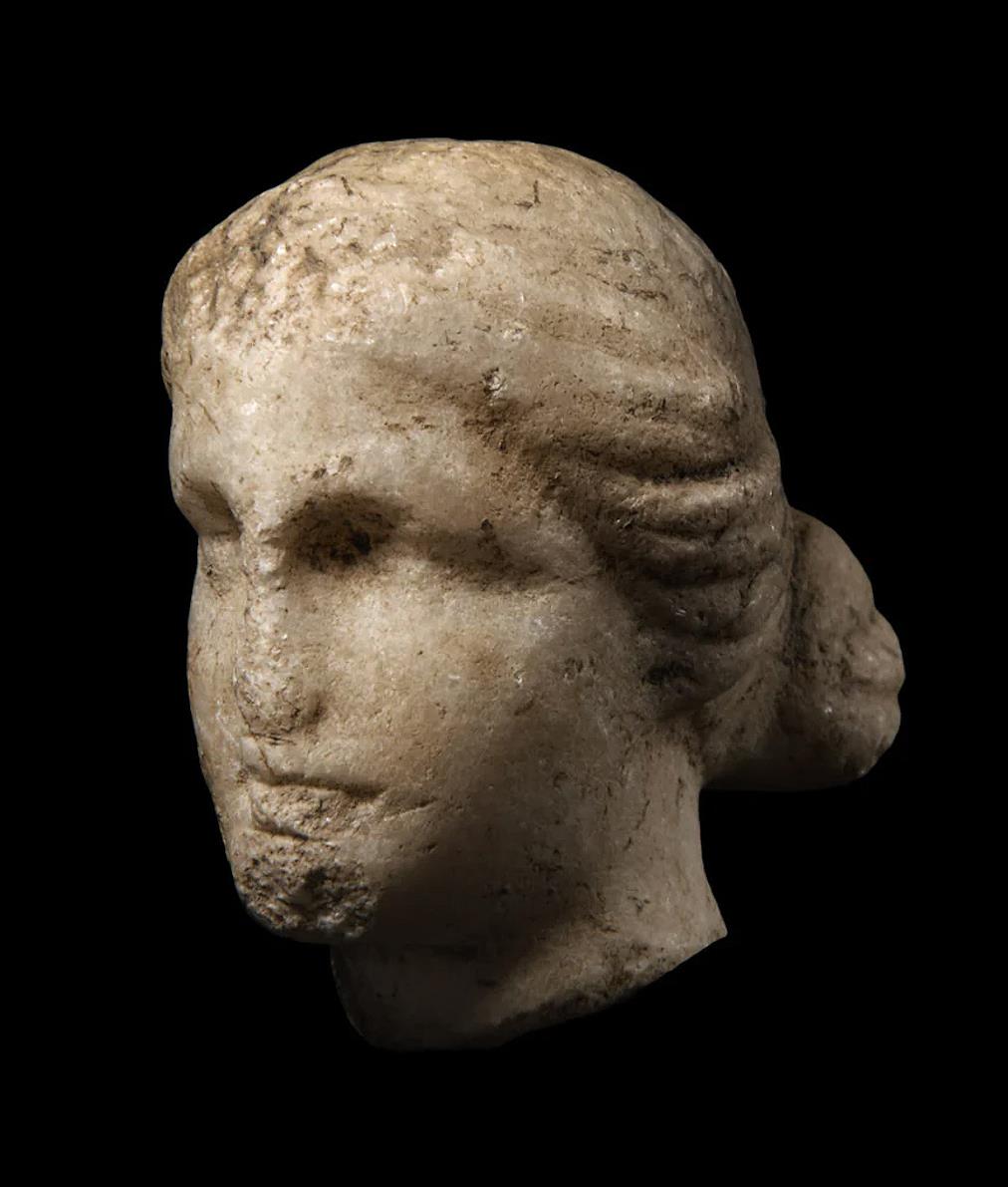 A FRAGMENTARY MARBLE HEAD OF A GODDESS. Probably Greek, circa 1st – 2nd century AD