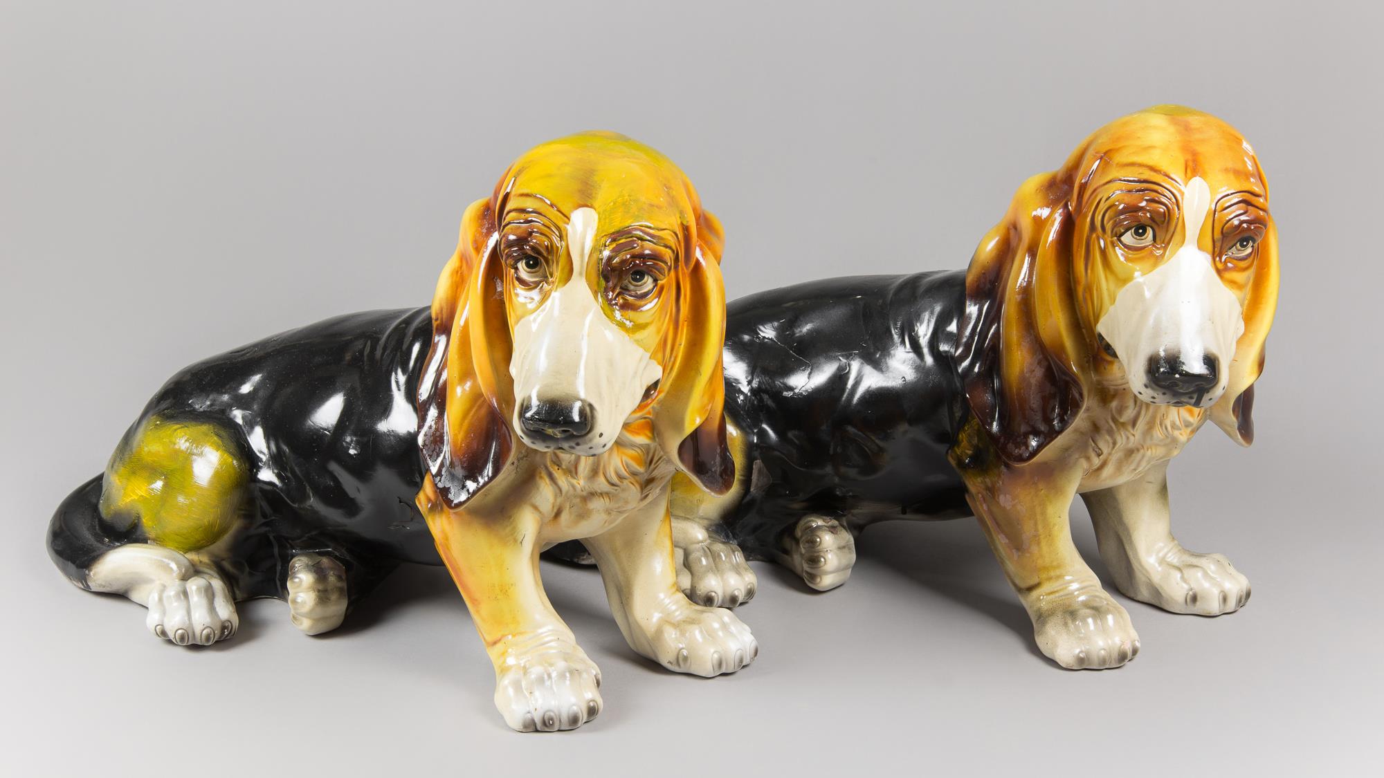 A PAIR OF MID-20TH CENTURY LIFE-SIZE GLAZED CERAMIC BASSET HOUND DOG SCULPTURES. (h 41cm x w 63cm