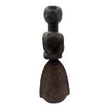 AN AFRICAN CARVED WOODEN FIGURAL HANDBELL Female figure with metal bell to base. (approx 28cm)