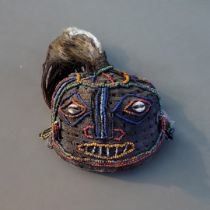 A VINTAGE TRIBAL AFRICAN BEADWORK AND SHELL MASK HEADDRESS Having animal hair finial, coloured glass