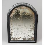 A 19TH CENTURY ARCHED WALL MIRROR WITH HEAVILY FOXED ORIGINAL MERCURY PLATE IN AN EBONISED FRAME. (h