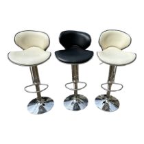 A PAIR OF CREAM LEATHER AND CHROME ADJUSTABLE BAR STOOLS Along with another in black. (84cm,