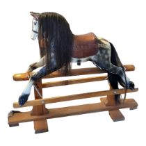 AN EARLY 20TH CENTURY CHILD’S DAPPLE GREY WOODEN ROCKING HORSE With real hair mane and tan leather