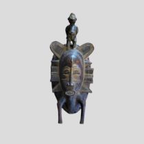 AN AFRICAN TRIBAL CARVED WOODEN SENUFO PASSPORT MASK Having a figural finial and carved