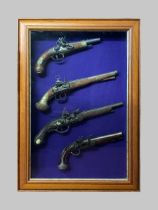 A COLLECTION OF IMITATION ANTIQUE PISTOLS IN A GLAZED FRAMED CASE.