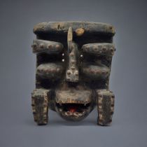 A SOUTH AMERICAN CARVED WOODEN MASK Protruding features with iron studs to edges. (approx 21cm x