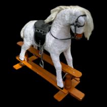 A CHILD'S SOFT GREY FUR ROCKING HORSE With leather saddle on a pine base. (140cm x 46cm x h 108cm)