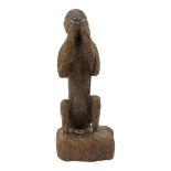 AN AFRICAN CAMEROON CARVED WOODEN FIGURE Seated pose with hands to mouth. (approx 21cm) Condition: