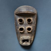 AN AFRICAN TRIBAL CARVED WOODEN GREBO 'KRU' MASK Four eye holes, square mouth. (approx 33cm)