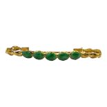 A VINTAGE CHINESE YELLOW METAL AND JADE BRACELET Five cabochon cut stones with scrolled yellow metal