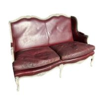 A FRENCH LOUIS XVI DESIGN CARVED WOOD AND PAINTED RED LEATHER TWO SEATER SETTEE The shaped back