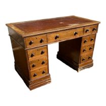 A VICTORIAN MAHOGANY DESK With tooled leather top above an arrangement of nine drawers. (120cm x