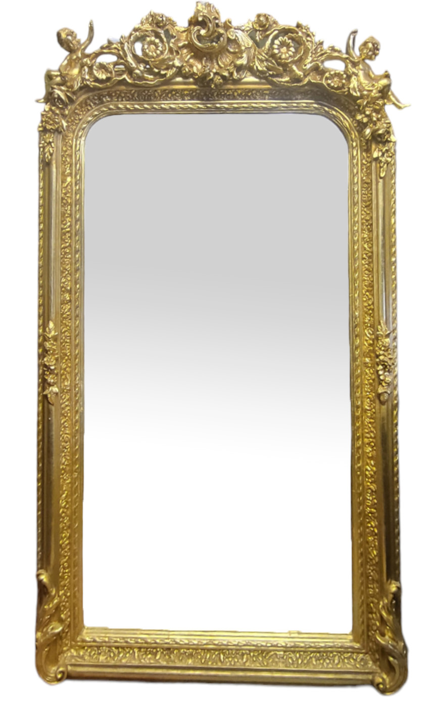 A VICTORIAN STYLE GILT FRAMED MIRROR With floral crest and putti above a bevelled plate. (82cm x