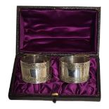 A CASED PAIR OF VICTORIAN SILVER SERVIETTE RINGS Having engraved border and numbered 1 and 2,