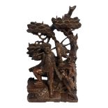 AN EARLY 20TH CENTURY ORIENTAL STYLE HARDWOOD CARVING OF A FOREST HUNTER Surrounded by animals and
