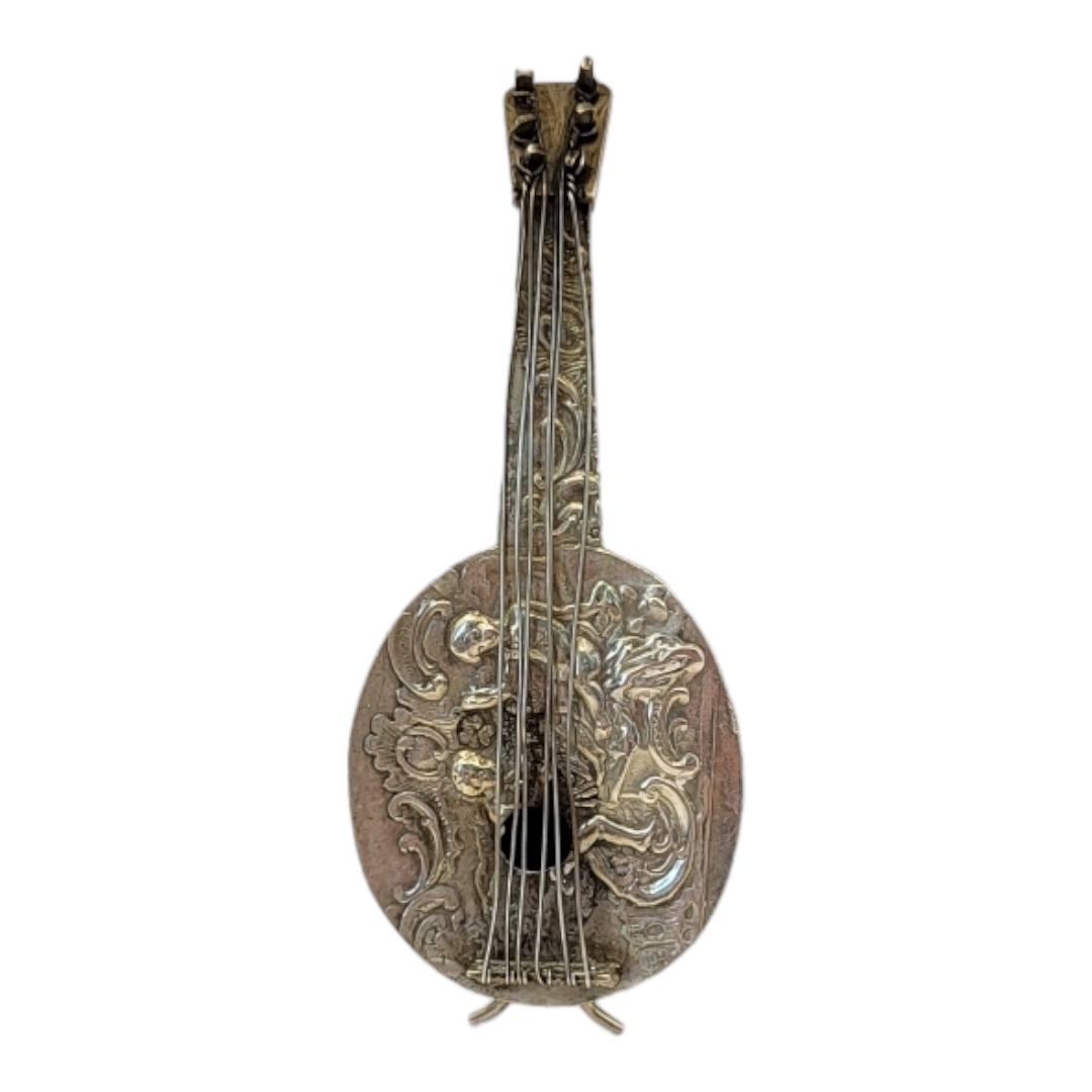 A VINTAGE CONTINENTAL SILVER NOVELTY MANDOLIN Having embossed figural decoration and scrolled