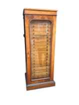 A HIGH VICTORIAN WALNUT CASED COLLECTOR’S CABINET With single arch glazed drawers, enclosing