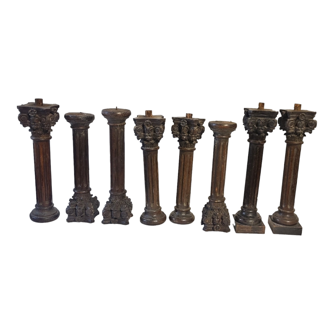 A SET OF EIGHT 19TH CENTURY CARVED PROVINCIAL OAK CORINTHIAN COLUMNS With ebonised patination. (42.