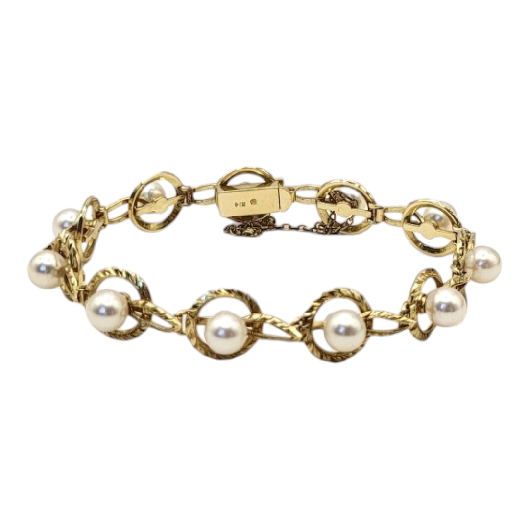 MIKIMOTO, A VINTAGE 14CT GOLD AND PEAL BRACELET Having a single row of pearls within a pierced