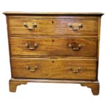 A GEORGIAN SOLID MAHOGANY CHEST OF THREE LONG DRAWERS Fitted with brass swan neck handles, on