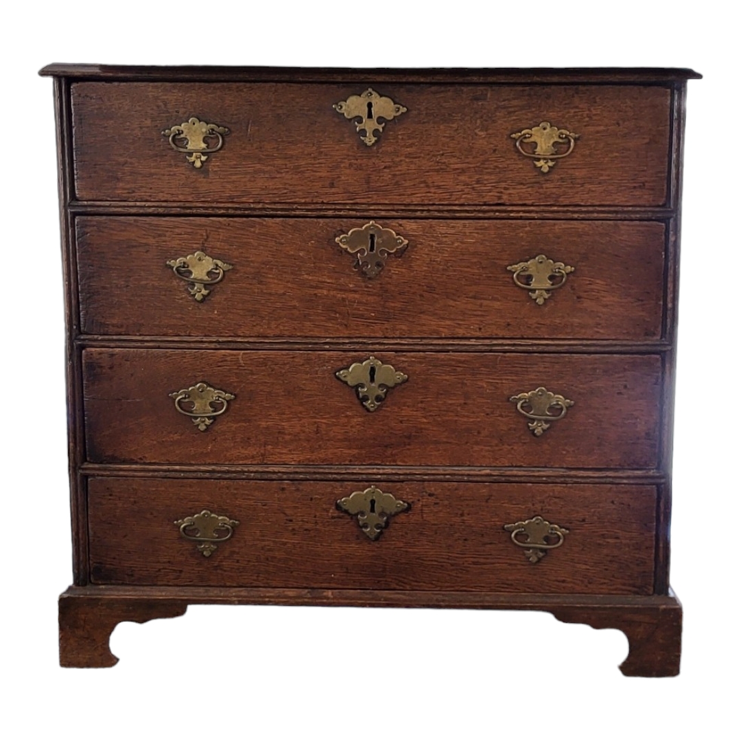 AN EARLY 18TH CENTURY OAK CHEST OF FOUR LONG DRAWERS Fitted original brass furniture, on bracket