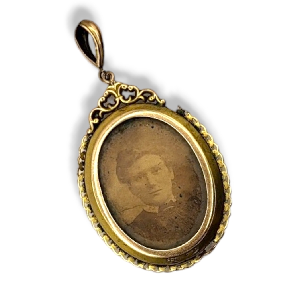 AN EDWARDIAN 9CT GOLD OVAL PENDANT LOCKET With compartments to front and rear. (approx 3cm x 4cm)