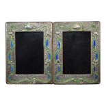 A PAIR OF ART NOUVEAU STYLE SILVER AND ENAMEL PHOTOGRAPH FRAMES Embossed floral design and wooden