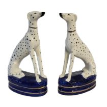 A PAIR OF 20TH CENTURY STAFFORDSHIRE POTTERY DALMATIAN DOGS Seated pose with royal blue ground. (