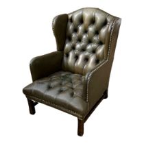 A MID CENTURY GEORGIAN STYLE CHESTERFIELD ARMCHAIR In green leather button back upholstery, on
