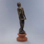 AN ART DECO STYLE BRONZE FIGURE FORMED AS A NUDE LADY HOLDING A MUSIC SHEET On rouge marble