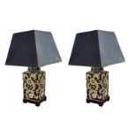 A PAIR OF ORIENTAL DESIGN FLORAL CERAMIC DECORATED TABLE LAMPS AND SHADES In cream on a deep blue