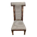 A LATE VICTORIAN BEECHWOOD PRAYER CHAIR In later fabric upholstery, on turned legs terminating on