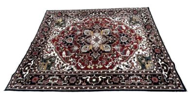 A 20TH CENTURY PERSIAN STYLE HERIZ CARPET Having central floral medallion on red and white ground,