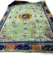 A LARGE DECORATIVE CHINESE CARPET with green ground and floral and flower decoration 275cm x 357cm
