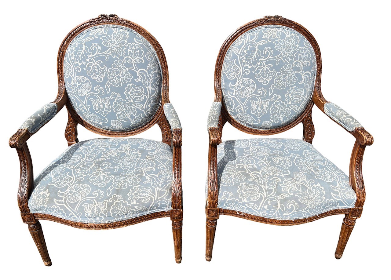 A PAIR OF 19TH CENTURY FRENCH LOUIS XVI DESIGN OPEN ARMCHAIRS The back carved with ribbons above