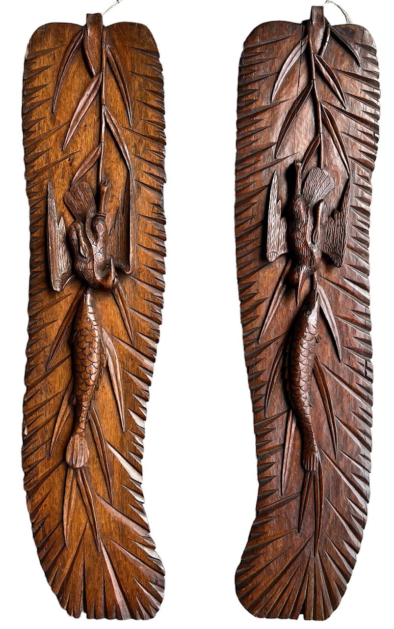 A PAIR OF DECORATIVE ORIENTAL CARVED WOOD WALL HANGING PANELS carved with bamboo birds and fish.