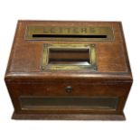 A LATE VICTORIAN OAK POSTBOX The slope top with engraved brass aperture for posting letters with a