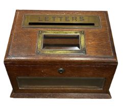 A LATE VICTORIAN OAK POSTBOX The slope top with engraved brass aperture for posting letters with a