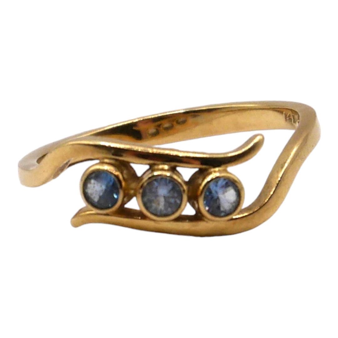 A 14CT GOLD AND BLUE SPINEL CROSSOVER RING Having three round cut blue spinels (approx. 3mm) set